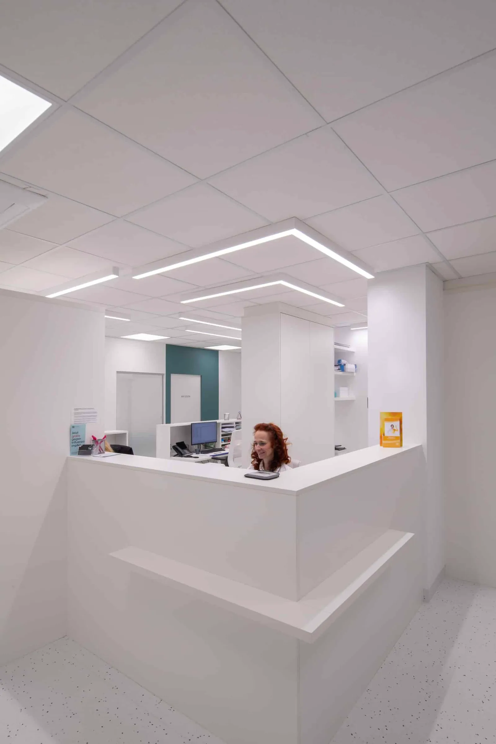 Heller Empfangsbereich der PVE Wien Nord mit Mitarbeiterin am Front Office